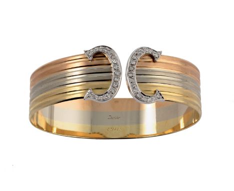 317 BRACCIALE IN ORO E DIAMANTI , 1980 CIRCA in oro tre colori a lastra con motivo a doppia C in diamanti. Firmato Cartier e 
