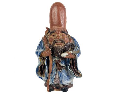 A Chinese model of an immortal, early 20th century. With staff in right hand and holding a scroll in left hand and wearing a 