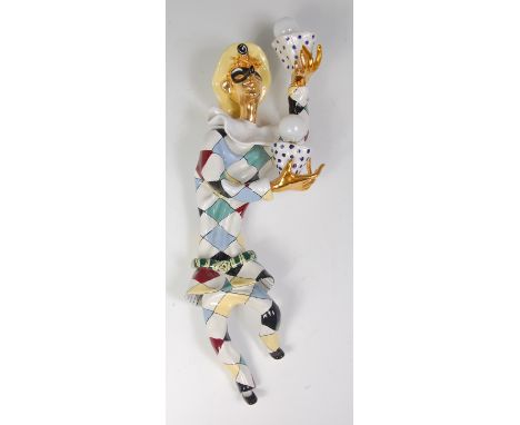An Italian San Polo painted and glazed ceramic twin branch wall light, in the form of a harlequin, of typical bright coloured