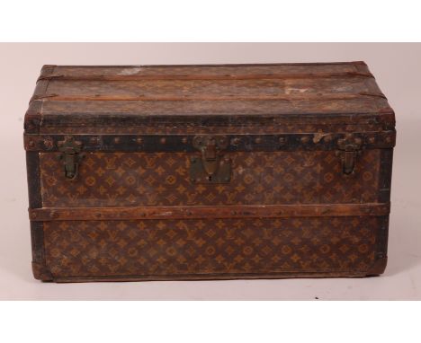 A small Louis Vuitton travelling trunk, having LV monogrammed canvas, leather and metal bound with reinforced outer wooden la