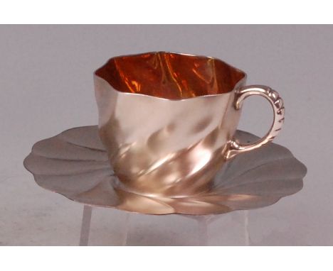 An Art Nouveau WMF silver plated teacup and saucer, of wavy ribbed form, the cup having a gilt wash interior, each with stamp