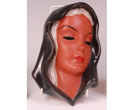 An Art Deco Goldscheider painted terracotta wall mask of a veiled woman, printed backstamp 'Goldscheider West Germany' and in