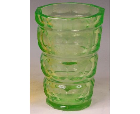 An Art Deco green tinted decagon sided heavy cut glass vase, of bulbous faceted flat-sided tapering form, with etched detail,