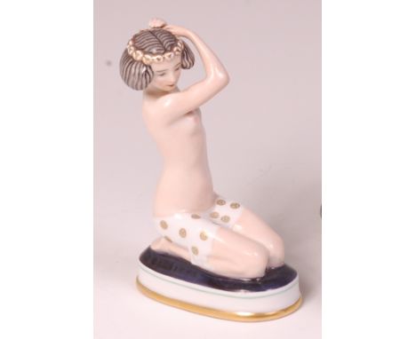 A Rosenthal glazed porcelain figure of a semi-nude female in kneeling pose, raised on integral oval base, impressed backstamp