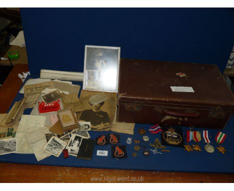 A brown suitcase containing birth and death certificates for The Flowers family, three 7th Armoured Desert Rat Cloth badges (