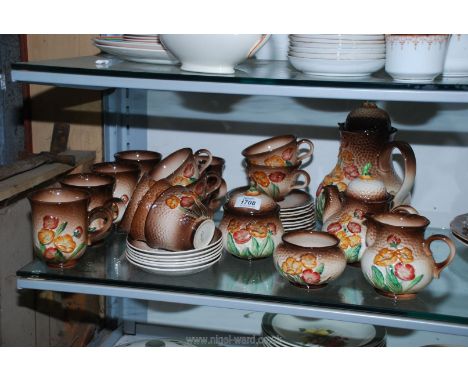 A Carlton Ware part tea and coffee service with embossed brown and floral pattern:coffee and teapots, mugs, cups, saucers, et