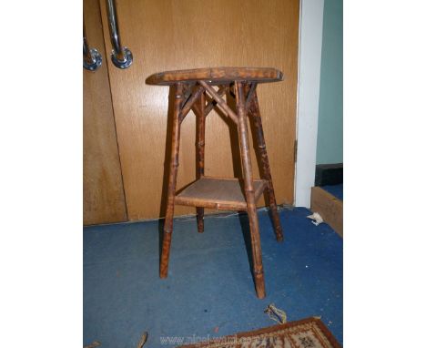 An octagonal cane conservatory table, having a lower shelf, 26'' high x 15 3/8'' diameter