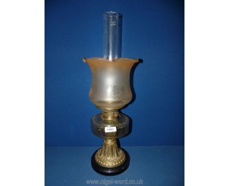 A brass based oil lamp with clear reservoir, beige etched shade and chimney, 22 1/2'' tall.