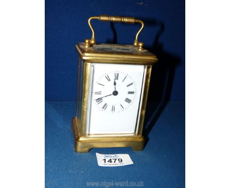 A bevelled windowed gilded metal cased Carriage Clock having Roman numerals and having the escapement visible through the top