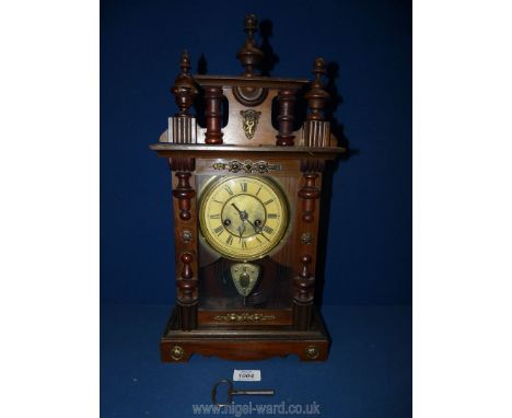 A Mantle clock, the face with Roman numerals, galleried pediment, pendulum and key, 19" high x 10" wide x 5" deep.