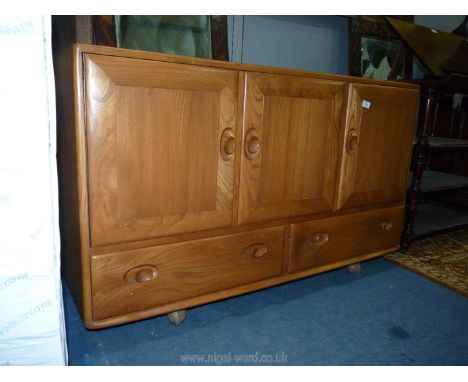 An Ercol Elm wood sideboard having three doors and a pair of drawers below, 61'' long x 18'' deep x 29 3/4'' wide. (One drawe