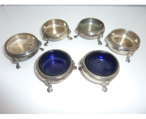 A set of four Georgian silver salt cellars, David Mowden, London, 1756 & 1763, each plain bulbous body on three hoof feet, wi