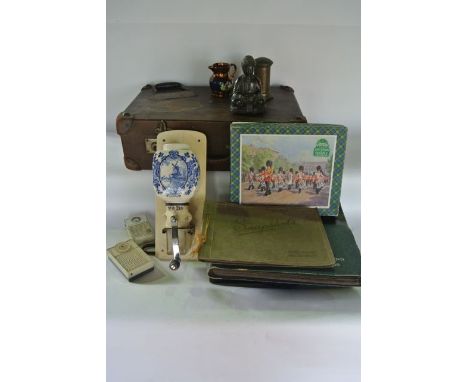 A vintage tan coloured briefcase with studded leather corners containing a cast metal study of a seated Buddha holding a vess