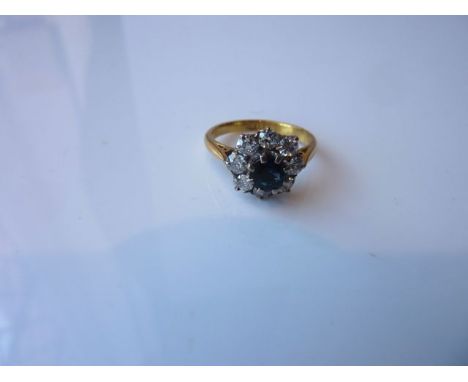 A sapphire and diamond flower head ring, centred with a round mixed-cut untested sapphire weighing approximately 0.64cts, wit