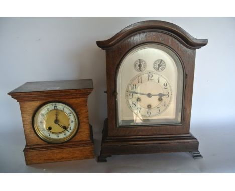 An Edwardian oak bracket clock, the arched silvered dial with regulator and chime/silent selector and a further oak cased man