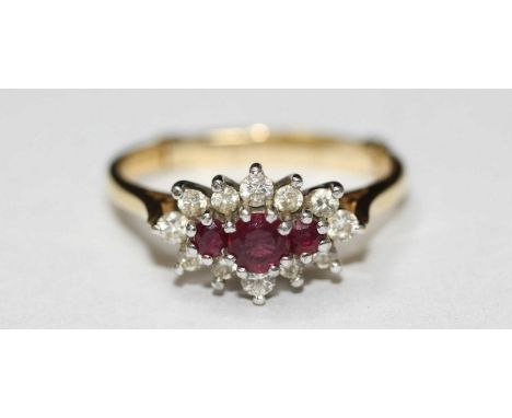 An 18ct gold, ruby and diamond cluster ring, set with three rubies, surrounded by twelve diamonds and with 9ct gold sizing ba