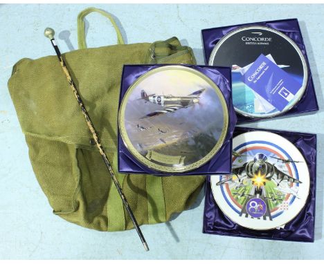 A green canvas parachute bag and a white metal topped swagger stick, together with three boxed Bradford Exchange wall plates 