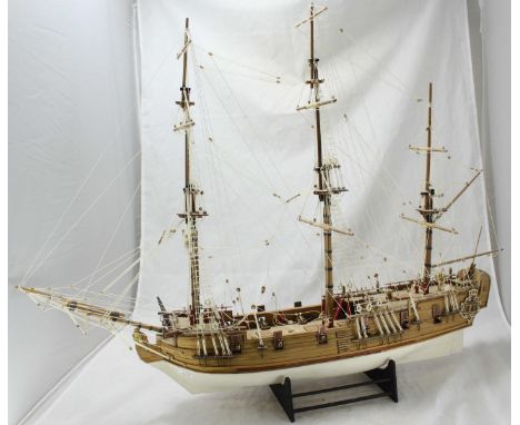 A hand-made wooden scale model of an 18th century three-masted 12-gun ship, with white-painted planked and pinned hull, fully