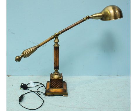 A modern stained wood and brushed brass adjustable lamp, on a raised support to square, pedestal base.