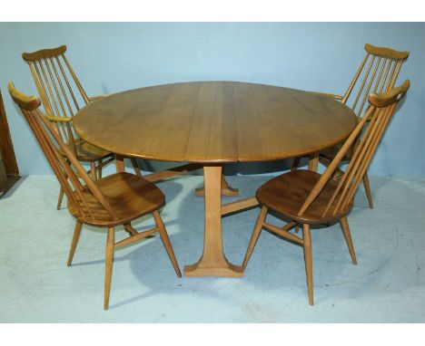 An Ercol light elm gate-leg dining table, measuring 140cm long when leaves are out, together with two Ercol carver chairs and