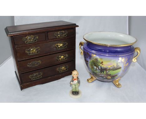 An Edwardian miniature chest of drawers, together with a blue and gilt pottery jardinière and a Hummel figure.