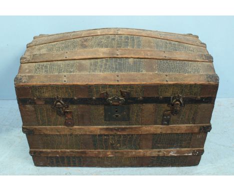 An early 20th century wood and metal-bound dome-top trunk with faux crocodile skin covering, 78cm wide