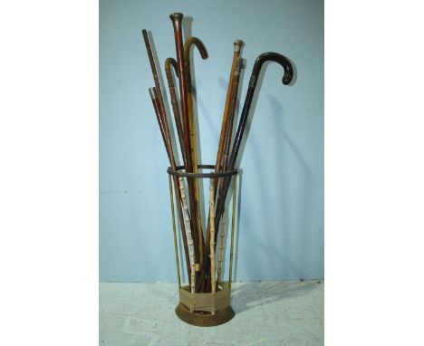 Three various silver-topped walking canes together with a horn-handled cane and other canes in bamboo stick stand