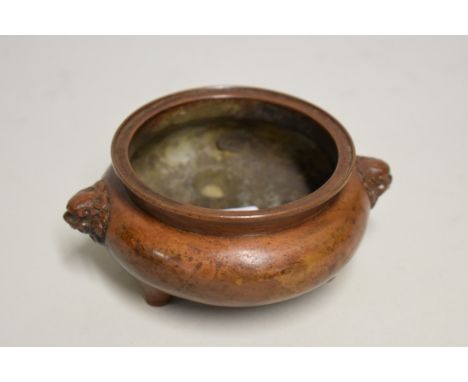 A Chinese bronze twin handled censer, with qilin mask handles, 12cm wide, 370g. 