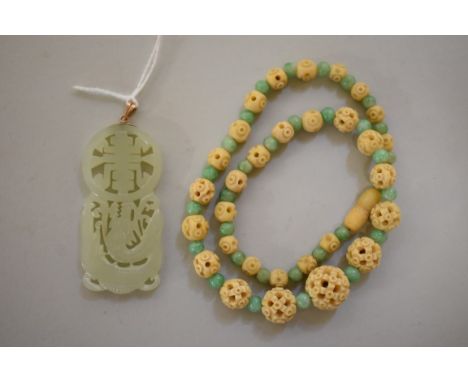 A Chinese carved and pierced celadon jade pendant, decorated with a dragon, 5.8cm high, the yellow metal lanyard stamped 'K10