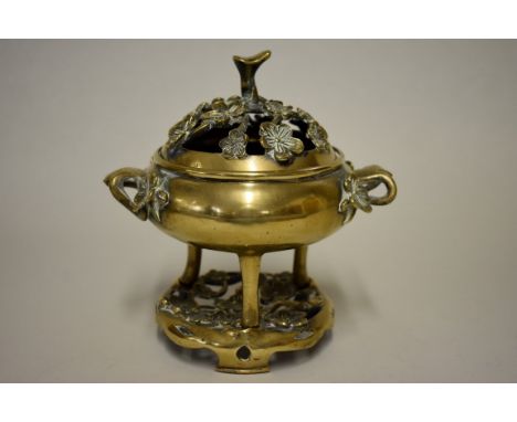A Chinese brass twin handled&nbsp;tripod censer, pierced cover and stand, 18cm high. 