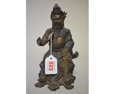 A Chinese bronze seated figure, with remains of painted and gilt decoration, 21.5cm high. 
