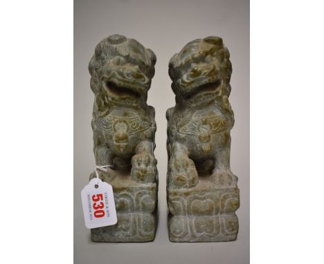 A pair of Chinese green jade or soapstone lion dogs, 21.5cm high. (2) 