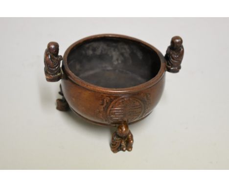 A Chinese bronze twin handled tripod censer,&nbsp;nine character seal mark to base,&nbsp;with figure handles and feet, 14cm w