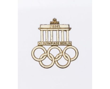 A 1936 Berlin Olympics visitors badge. Steel base metal with gilt finish and infilled with white enamel marked 'Paul Mann &am