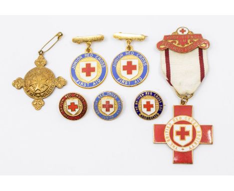 A collection of British Red Cross enamel medallions and badges, including a proficiency medal, two Junior Red Cross First Aid