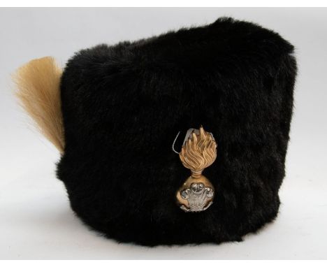 British Army bear skin hat, fitted with a silvered and gilt brass badge, of the Royal Welsh Fusiliers, attached to the side i