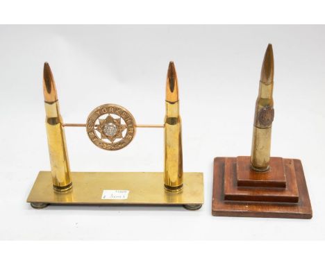 A WWI era trench art bullet table lighter, on a stepped wooden plinth, the bullet has an applied RAF badge motif, plus a regi