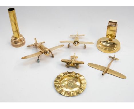 A small collection of trench art style brass pieces, including four models of WWII era planes of modern manufacture, a brass 