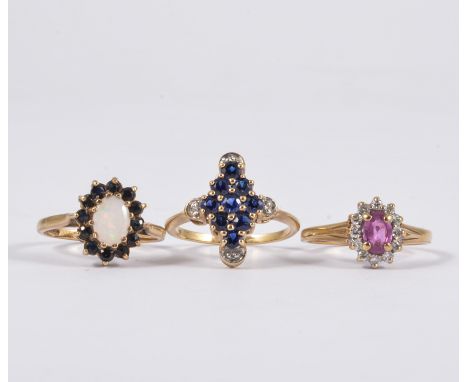 Three dress rings, a hallmarked 9 carat yellow gold cluster set with an oval cabochon cut opal and twelve sapphires, a marqui