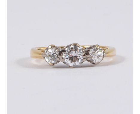 A traditional diamond three stone ring, the brilliant cut diamonds, slightly graduating in size, claw set in a hallmarked 18 