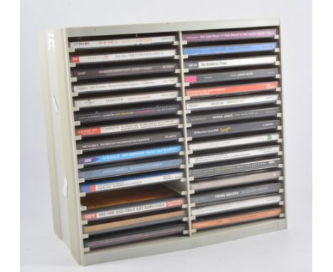 Collection of music CDs and cassette tapes, including classical, pop, Bob Dylan, Johnny Cash, Queen and others, housed in a p