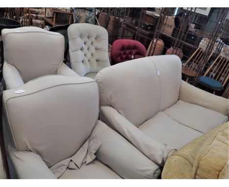 A PAIR OF EDWARDIAN EASY CHAIRS, WITH TURNED LEGS AND BRASS CASTERS, upholstered in white cambric with loose covers, each 82 