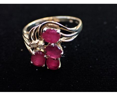 A 'RUBY' RING ON A 9CT GOLD SHANK, the four mix oval-cut 'rubies in a 9ct gold open-work setting, ring size Q-R (2.85 grams)