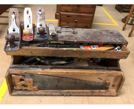 Collection of vintage woodworking tools including planes in a wooden carpenters box
