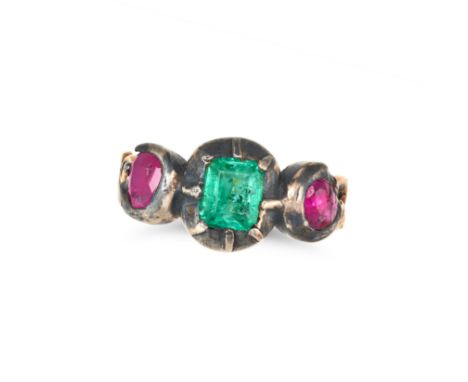 AN ANTIQUE EMERALD AND RUBY RING in yellow gold and silver, set with an octagonal step cut emerald between two oval cut rubie