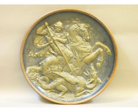 A German terracotta plaque of George and the Dragon, with paper label inscribed for 'Unterberger in Innsbruck', 42cm diameter