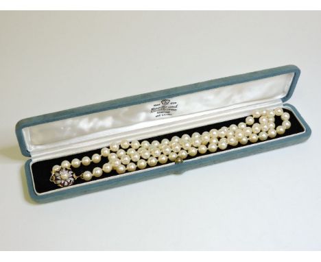 A single row uniform cultured pearl necklace, with a two colour gold and cultured pearl clasp, marked 750, case by Boodle and