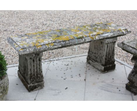 A reconstituted stone garden bench, 129cm wide