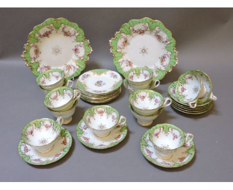 A Victorian Staffordshire part tea service, with green gilt and floral borders, two cake plates, fourteen cups, and eleven sa
