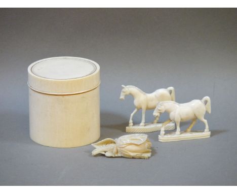 An antique ivory trinket box, two carved horses, and a flower